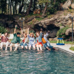 Friends celebrating by the pool with drinks